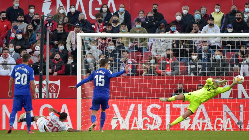 Fotografija: Vratar Getafeja David Soria je imel veliko prometa in ni mogel preprečiti zmagovitega gola Seville. FOTO: Cristina Quicler/AFP