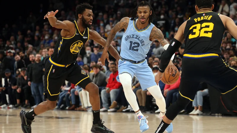 Fotografija: Ja Morant prodira ob Andrewu Wigginsu na obračunu v FedExForumu vTennesseeju. FOTO: Petre Thomas/USA TODAY Sports