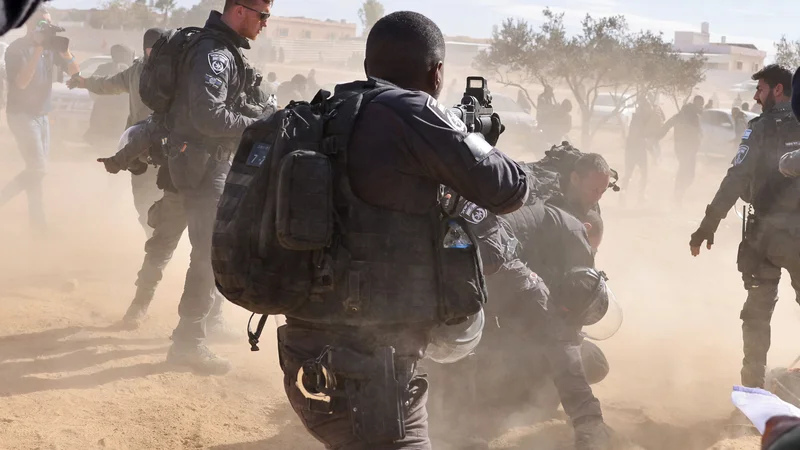 Fotografija: V izraelski vasi Sa'we al-Atrash v puščavi Neguev je izraelska policija aretirala moškega med protestom beduinov proti projektu pogozdovanja Judovskega nacionalnega sklada (JNF). Izraelska vlada je danes želela zmanjšati napetosti z beduini zaradi kontroverznega projekta zasaditve dreves v puščavi Negev po več dneh nemirov. Foto: Ahmad Gharabli/Afp