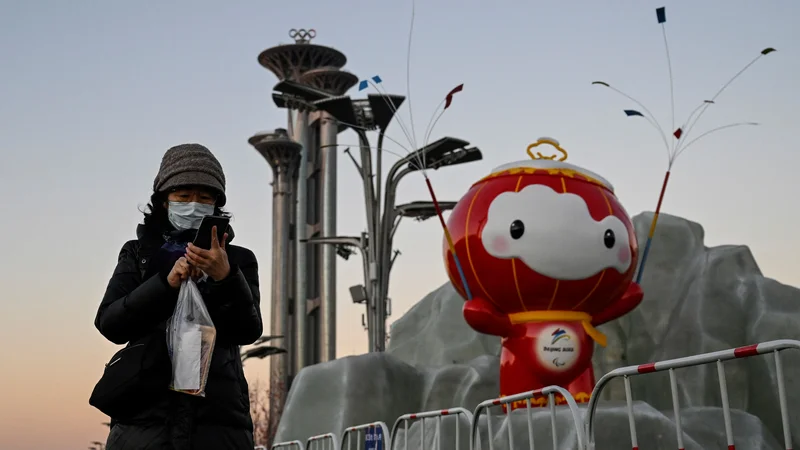 Fotografija: Ali tudi maskota olimpijskih iger gleda čez ramo obiskovalki Pekinga? FOTO: Jade Gao/AFP