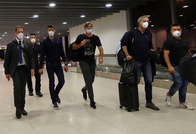 Novak Đoković s spremljevalci na letališču v Melbournu. FOTO: Loren Elliott/Reuters
