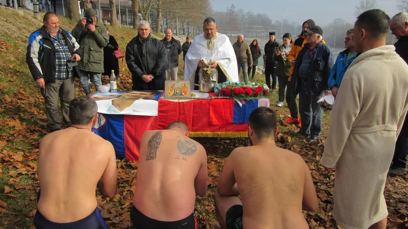 Fotografija: Mizo, na kateri ima paroh vse, kar potrebuje za blagoslov in krajši obred, vsako leto ovijejo v slovensko in srbsko zastavo. Tokrat je bila na njej še ogromna fotografija Novaka Đokovića. FOTO: Špela Kuralt/Delo