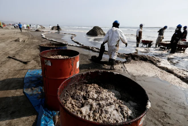 Na obali Lime (Peru) odstranjujejo olje, ki so ga prinesli ogromni valovi po izbruhu vulkana in cunamijih v Tongi. FOTO: Angela Ponce Reuters
