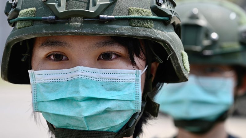 Fotografija: Tajvanska vojakinja na začetku pandemije covida-19. Tajvan spada med države, ki so virus dobro zamejile. FOTO: Sam Yeh/AFP
