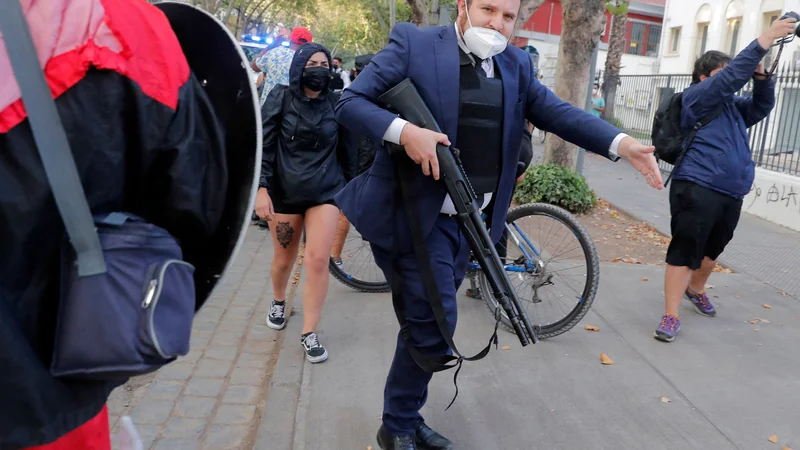 Fotografija: Preiskovalni policist se sooča s sorodniki pripornikov med civilno vstajo proti socialni neenakosti v Santiagu, ki se je začela že oktobra 2019. Protestniki so se odpravili proti vladi novoizvoljenega čilskega predsednika Gabriela Borica. Foto: Javier Torres/Afp