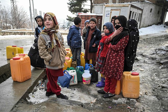 Otroci čakajo na polnjenje kanistrov z vodo v Kabulu januarja 2022. FOTO: Mohd Rasfan/Afp
