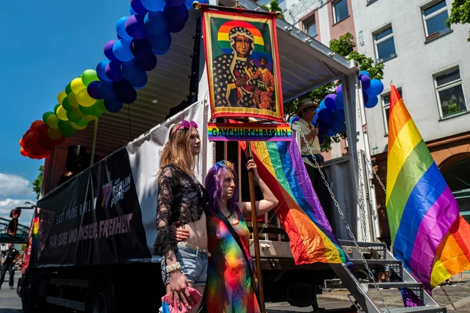 (FILES) This file photo taken on June 26, 2021 shows demonstrators taking part in an LGBTQ pride march and displaying a Gay Church Berlin banner in Berlin. - Around a hundred German LGBT+ Catholics employed by the church or being active in their parishes published their coming-out on January 24, 2022, denouncing the discrimination and exlusion they are suffering and claiming free access to pastoral professions. (Photo by John MACDOUGALL / AFP)