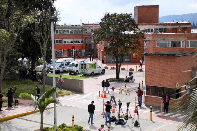 Ljudje so se zbrali pred kliniko La Sabana, kjer naj bi operirali Egana Bernala. FOTO: Foto Luisa Gonzalez/Reuters
