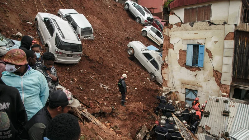 Fotografija: Gasilci v Antananarivu iščejo morebitne preživele pod ruševinami, potem ko se je po močnem deževju parkirišče z več avtomobili zrušilo na hiše. Reševalci so pod ruševinami našli pet trupel (štiri otroke in enega odraslega), iščejo pa še dve pogrešani osebi. Antananarivo in več drugih regij na Madagaskarju so prizadele močne tropske nevihte, ki so povzročile 34 smrtnih žrtev in prizadetih več kot 62.000 ljudi. Foto: Rijasolo/Afp