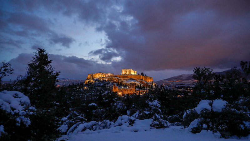 Fotografija: Močno sneženje je Atenam prineslo neobičajne vedute, a tako kot drugod v Grčiji tudi zaprte banke, šole, večino trgovin in nekaterih drugih javnih servisov. FOTO: Costas Baltas/Reuters

