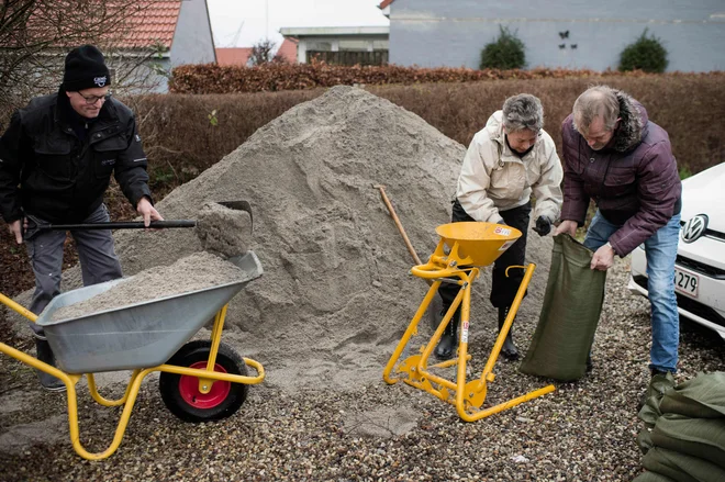  Na Danskem je bilo v pripravljenosti 10.000 reševalcev, ki so prebivalcem pomagali polniti protipoplavne vreče. FOTO: Tim Kildeborg Jensen/AFP
