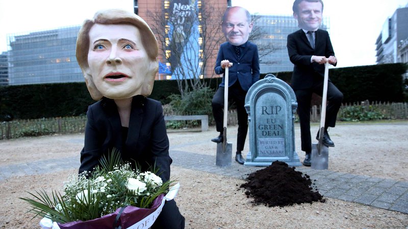 Fotografija: Aktivisti z maskami predsednice evropske komisije Ursule von der Leyen, nemškega kanclerja Olafa Scholza in francoskega predsednika Emmanuela Macrona kritizirajo novo razvrščanje naložb kot pogreb zelenega načrta EU. FOTO: François Walschaerts/AFP
