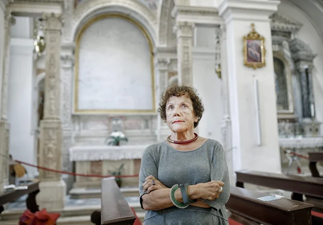 Sonja Ana Hoyer pred praznim oltarjem cerkve sv. Frančiška, ki že dolgo čaka na Carpaccia: »Dragocene slike se bodo vrnile, morda sto let po tem, ko so jih odnesli.« Foto Blaž Samec
