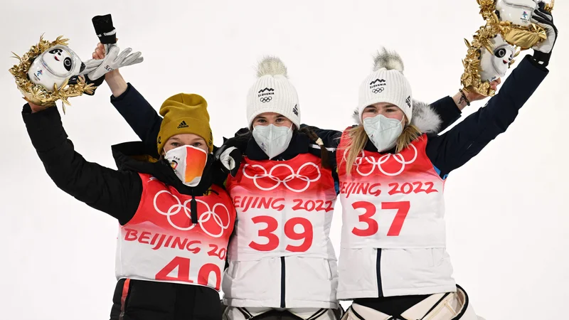 Fotografija: Čudovit pogled na prvo trojico (z desne): srebrna Katharina Althaus, zlata Urša Bogataj in bronasta Nika Križnar. FOTO: Christof Stache/AFP