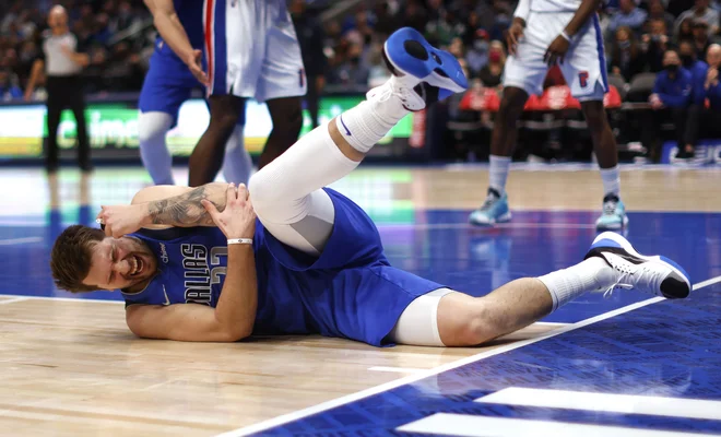 Luka Dončić je občutil tudi trdoto parketa v American Airlines Centru. FOTO: Ron Jenkins/AFP
