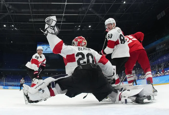 Reto Berra s soigralci ustavlja Mihaila Grigorenka med sredinim obračunom v kitajski metropoli. FOTO:&nbsp;Matt Slocum/Reuters
