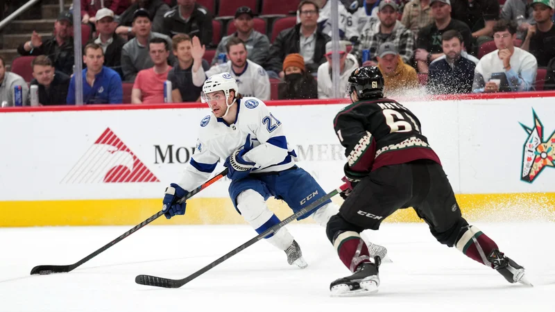 Fotografija: Brayden Point (v belem dresu) prodira s ploščkom ob branilcu Arizona Coyotes Dysinu Mayu v zadnji tretjini tekme v dvorani Gila River Arena. FOTO: Joe Camporeale/USA Today Sports