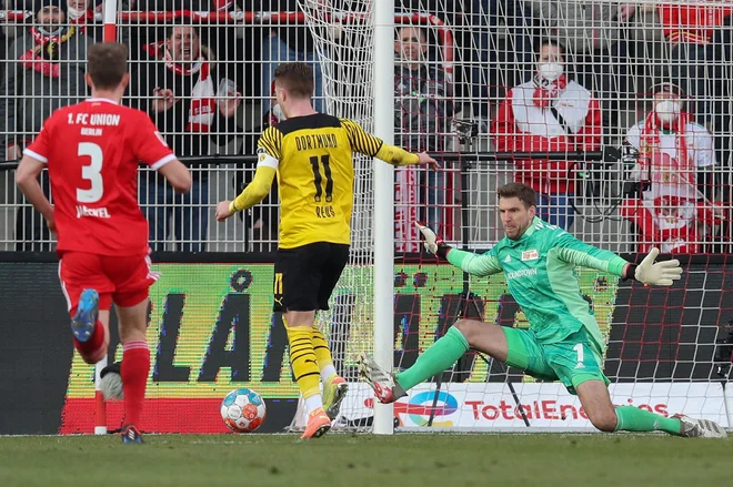 Marco Reus pred vratarjem&nbsp;Andreasom Luthejem&nbsp;na nedeljskem obračunu v Berlinu. FOTO:&nbsp;Ronny Hartmann/AFP
