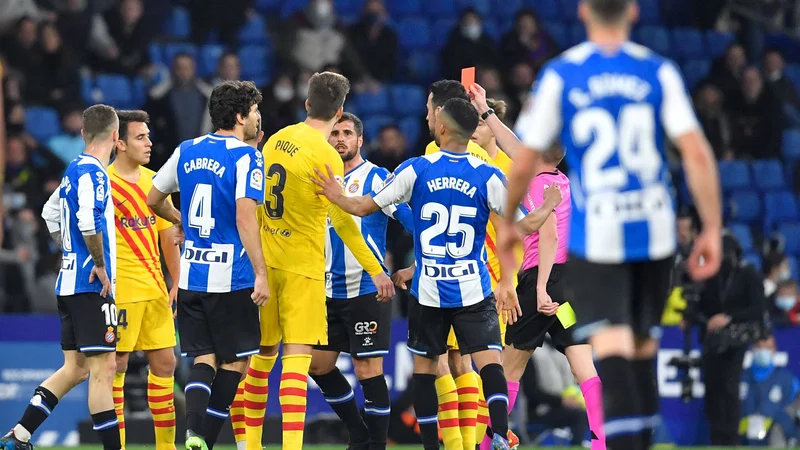 Fotografija: Gerard Pique (št. 3), med navijači Espanyola daleč najbolj nepriljubljen član Barcelone, je igrišče zapustil z rdečim kartonom. FOTO: Pau Barrena/AFP