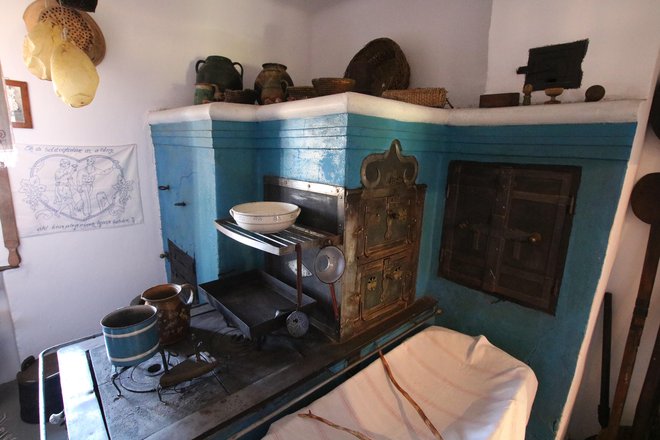 V Škerlakovi hiši v Krplivniku je posebej zidan štedilnik v tradicionalni kuhinji. FOTO: Jože Pojbič
