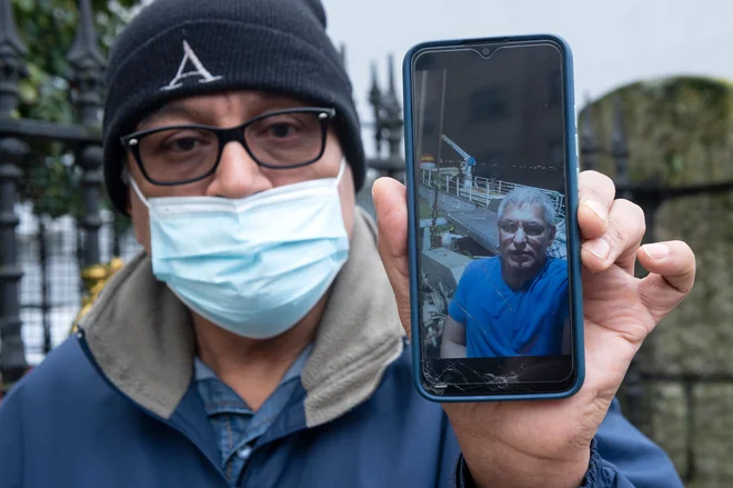 Sorodnik kaže fotografijo Rogelia Franca, enega od pogrešanih članov posadke na ribiški ladji, ki je potonila v ponedeljek. FOTO: Miguel Riopa/AFP
