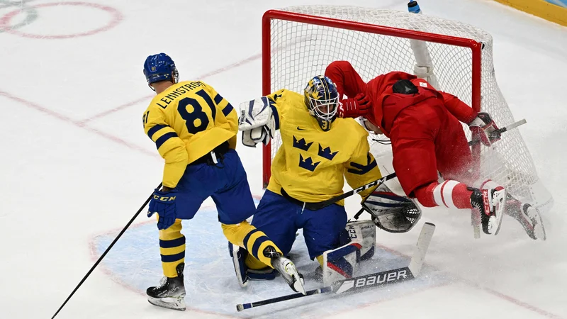 Fotografija: Pavel Karnauhov je ob vratarju Larsu Johanssonu končal v njegovi mreži med polfinalnim obračunom v Pekingu. FOTO: Anthony Wallace/AFP
