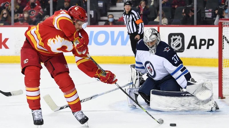 Blake Coleman poskuša premagati Connorja Hellebuycka&nbsp;v zadnji tretjini tekme, ki jo je gostila dvorana Scotiabank Saddledome v Calgaryju. FOTO: Candice Ward/USA Today Sports
