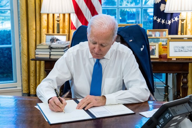 Ameriški predsednik Joe Biden ob podpisu pogodbe, ki prepoveduje kakršno koli transakcije v separatističnih republikah.  FOTO: Bela hiša/ Reuters
