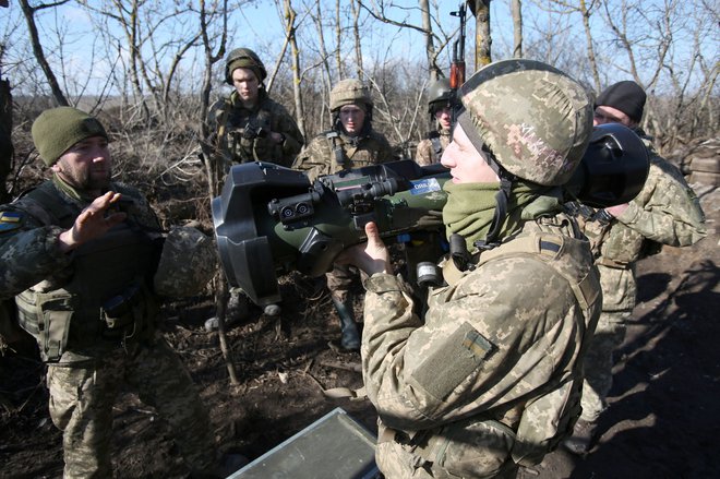 Uslužbenci ukrajinskih vojaških sil na frontni črti s separatisti, ki jih podpira Rusija, v bližini vasi Novognativka v regiji Donetsk pregledajo švedsko-britansko prenosno protitankovsko vodeno raketo NLAW, ki je bila prestavljena enotam kot del britanske vojaško-tehnične pomoči. FOTO: AFP
