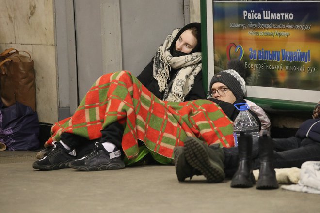 Ljudje počivajo na tleh postaje podzemne železnice, ki jo uporabljajo kot zavetje za zračne napade. FOTO: Irakli Gedenidze/Reuters

