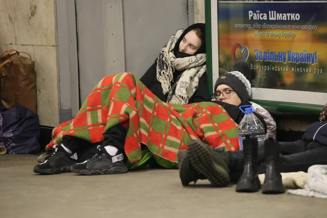 Ljudje počivajo na tleh postaje podzemne železnice, ki jo uporabljajo kot zavetje za zračne napade. FOTO: Irakli Gedenidze/Reuters