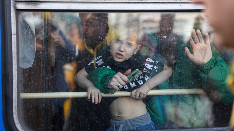 Fotografija: Ženska z otrokom na vlaku za evakuacijo, ki je iz Kijeva namenjen v Lvov. FOTO: Umit Bektas/Reuters
