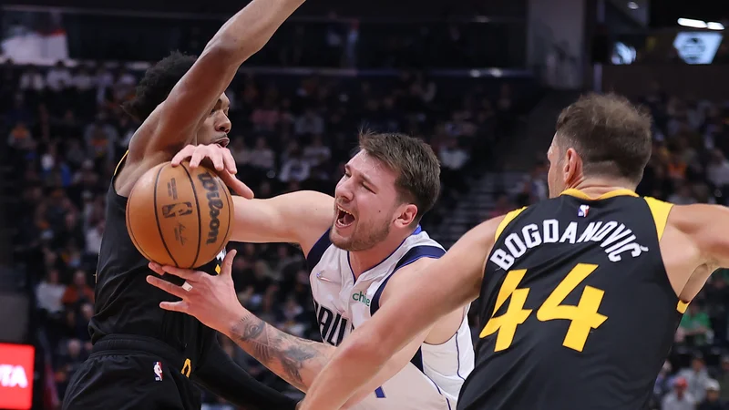 Fotografija: Prodor Luke Dončića pod prekrškom Trenta Forresta (levo) v prvi četrtini dvoboja v Vivint Areni v Salt Lake Cityju. FOTO: Rob Gray/USA Today Sports
