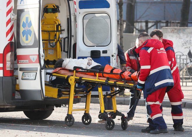 Reševalci pomagajo ranjeni ženski. FOTO: Gleb Garanich/ Reuters
