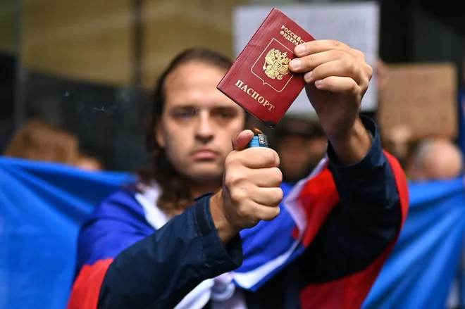 Ruski moški, ki živi v Sydneyju, je v znak podpore Ukrajini med protestom proti ruski invaziji na Ukrajino zažgal svoj potni list. Foto: Steven Saphore/Afp

 
