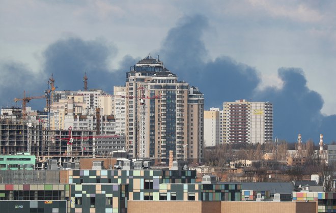 Zaradi obstreljevanja se v ozadju Kijeva dviga dim. FOTO: Irakli Gedenidze/Reuters
