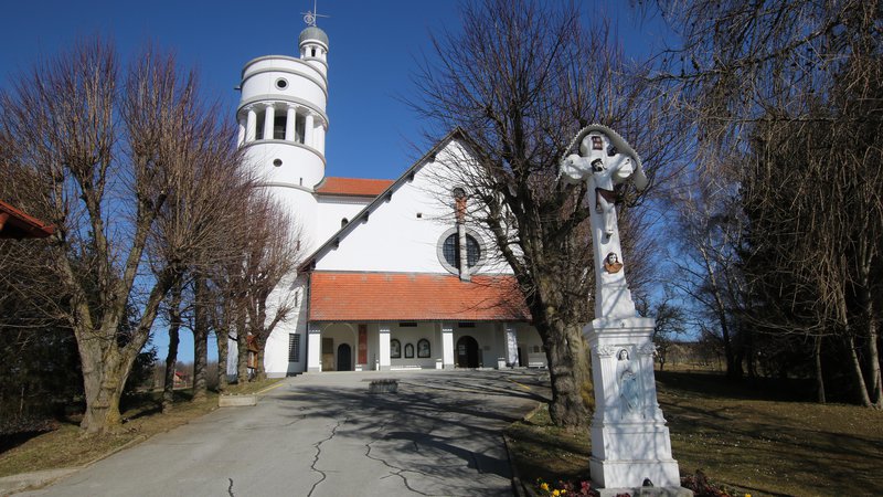 Fotografija: Domačini Plečnikovi cerkvi v Bogojini vzneseno pravijo bela golobica, čeprav so včasih nekateri valjasti zvonik primerjali s kadjo za kisanje zelja. FOTO: Jože Pojbič
