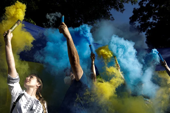 Ljudje v mehiški prestolnici držijo bakle z barvami ukrajinske zastave na protivojnem protestu pred ruskim veleposlaništvom po invaziji Rusije na Ukrajino. FOTO: Luis Cortes/Reuters
