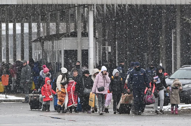 Begunci, ki prihajajo iz Ukrajine, na ukrajinsko-romunski meji v Siretu. FOTO: Daniel Mihailescu/AFP
