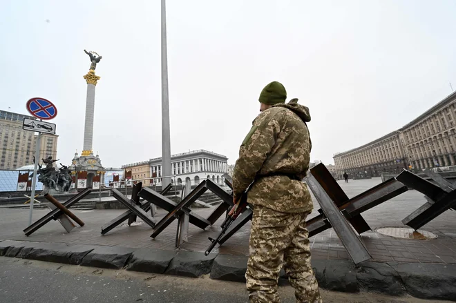 Borec ukrajinskih teritorialnih obrambnih sil varuje protitankovske konstrukcije na položaju na Trgu neodvisnosti v Kijevu. FOTO: Sergei Supinsky/AFP