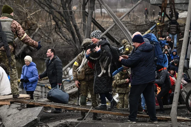 Ljudje odhajajo iz Irpina. FOTO: Aris Messinis/AFP
