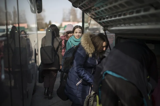 Člani in članice Ukrajinskega mladinskega simfoničnega orkestra na železniški postaji Záhony ob ukrajinski meji. Z dvema avtobusoma so jih prepeljali v Ljubljano. FOTO: Jure Eržen/Delo
