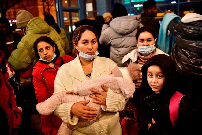 Mati z otroki po begu na postaji Nyugati v Budimpešti. FOTO: Marton Monus/Reuters