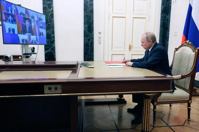 Vladimir Putin, ki je zasedanje ruskega varnostnega sveta vodil prek videopovezave, v vojno proti Ukrajini vabi tudi prostovoljce. FOTO: Mikhail Klimentyev/AFP
