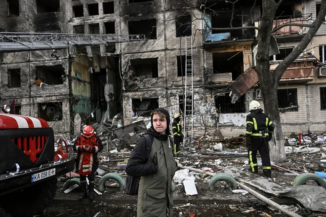 Osemnajstletnik v enem od uničenih predmestij Kijeva. FOTO: Aris Messinis/AFP
