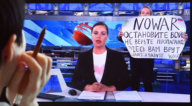 Urednica ruske televizije Marina Ovsjanikova je v ponedeljek zvečer na ruski državni televiziji s protestnim plakatom in glasnimi vzkliki prekinila poročila v živo. FOTO: AFP
