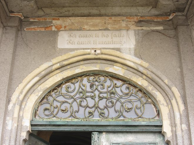 Napis nad vrati dvorca, ki v prevodu pomeni: »Za ljubezen sem te ustvaril, za ljubezen te ohranjam.« FOTO: Špela Kuralt/Delo
