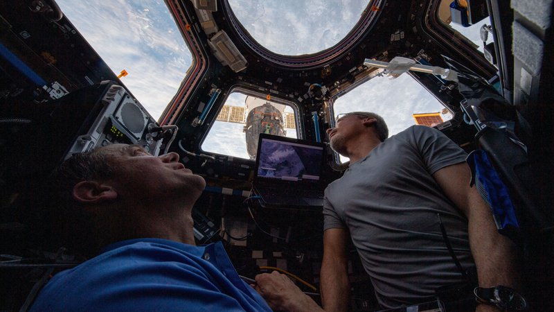 Fotografija: Ameriška astronavta Mark Vande Hei (desno) in Thomas Marshburn gledata Zemljo skozi znamenito kupolo. FOTO: Nasa
