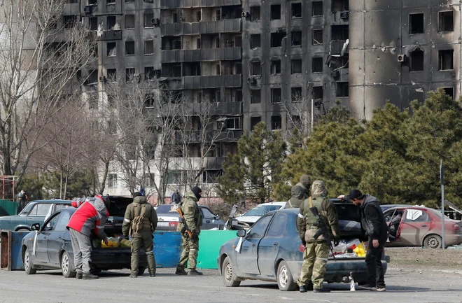 Uslužbenci proruskih čet preverjajo avtomobile v Mariupolju. FOTO: Alexander Ermochenko/Reuters
