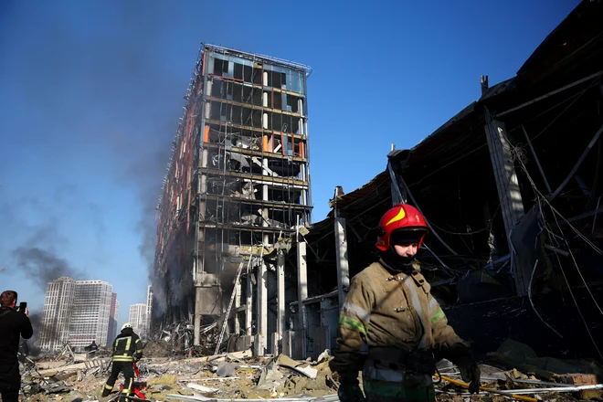 Reševalci delajo na kraju bombnega napada v nakupovalnem centru v Kijevu. FOTO: Marko Djurica/Reuters
